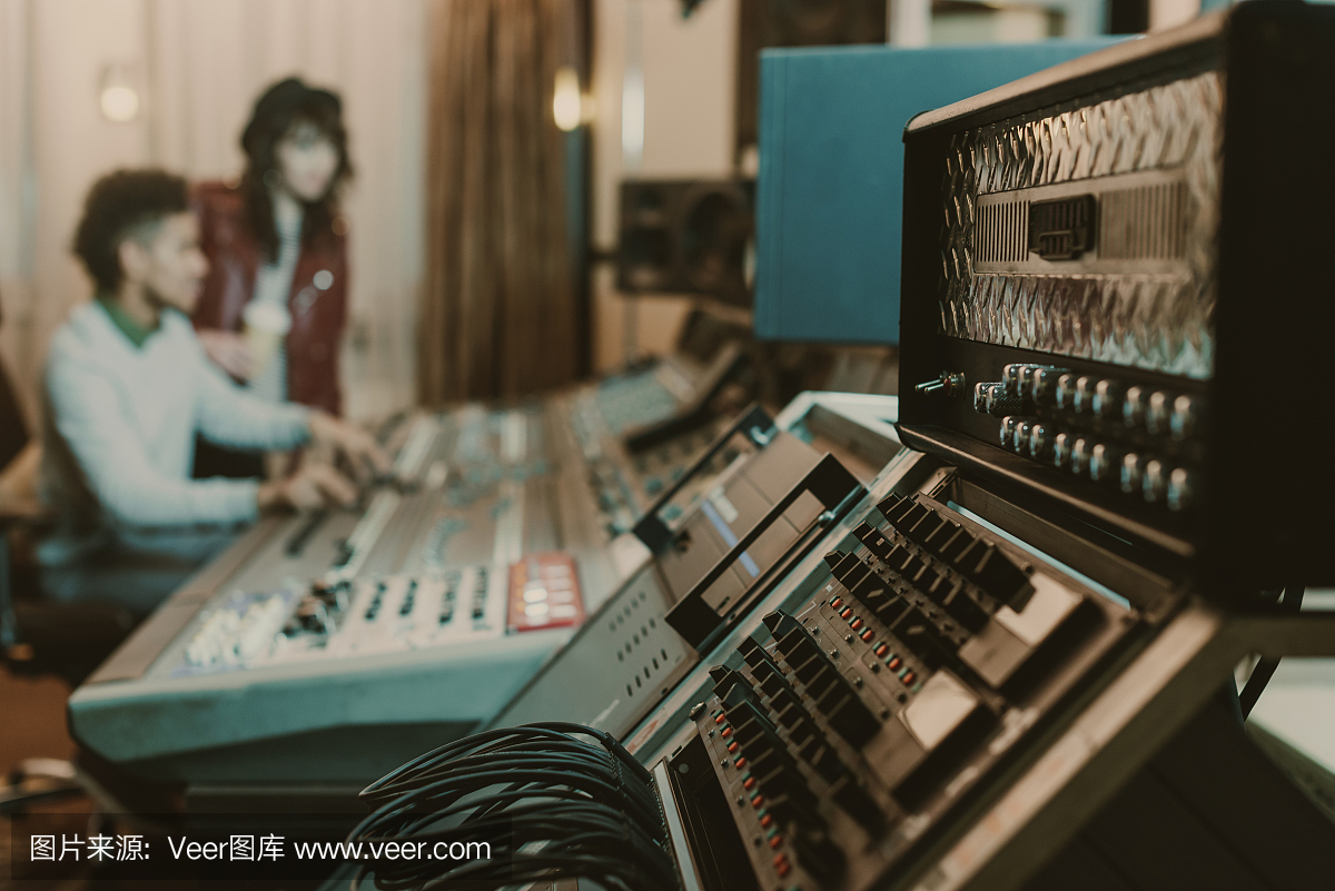 近距離拍攝錄音棚的擴音器,后面是模糊的制作人